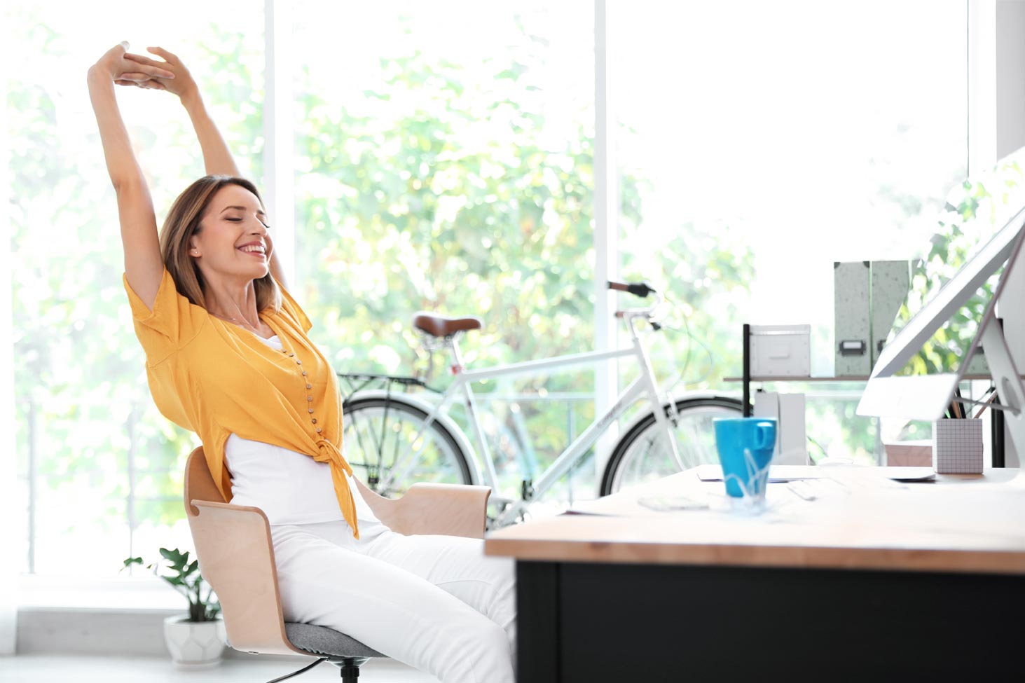 Small business bookkeeper taking a mindful break to manage stress and maintain health for better business performance.